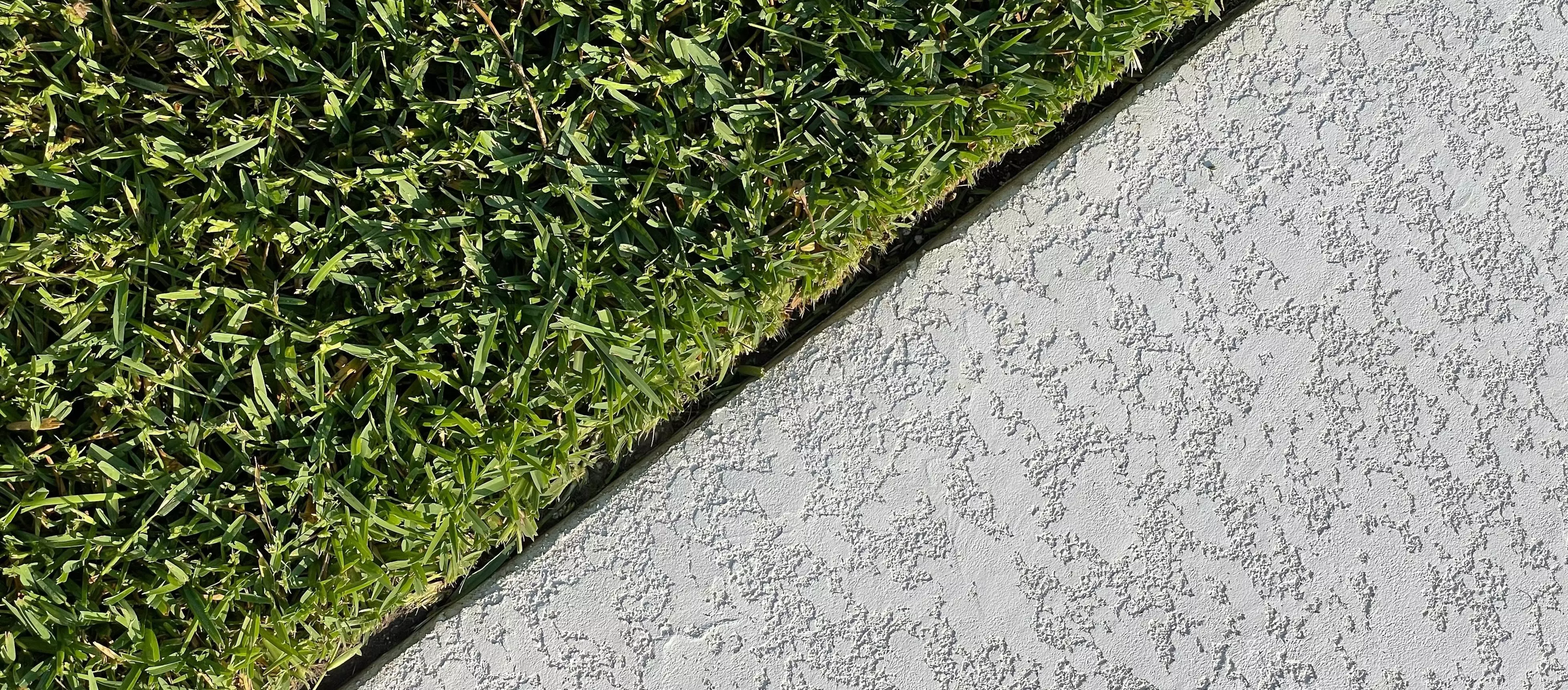 Diagonale Trennung zwischen Gras und Beton